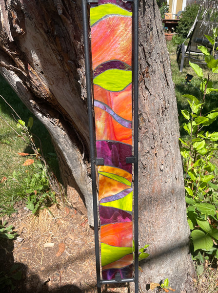Stained glass garden stake in orange, lime green and purple