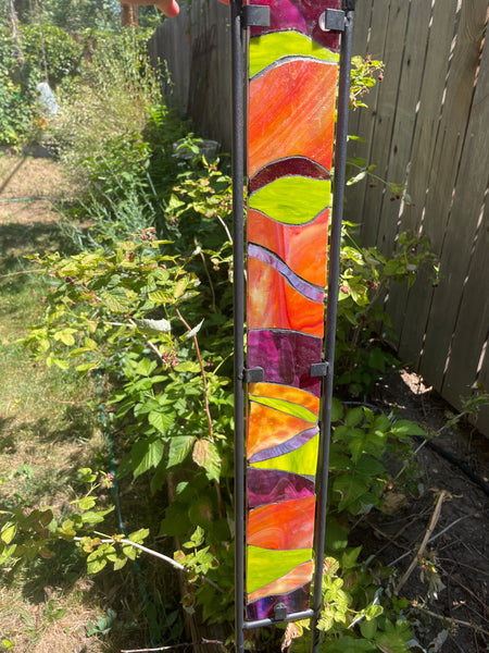 Stained glass garden stake in orange, lime green and purple